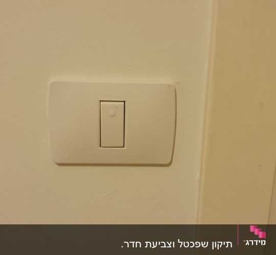 מתג חשמל על קיר צבוע בלבן